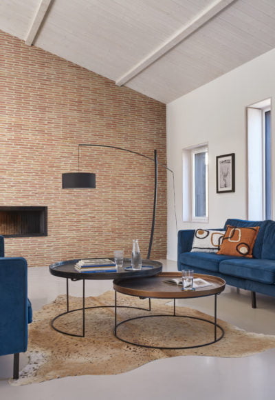Salon chaleureux avec mur en briquette ton rouge de chez ORSOL.